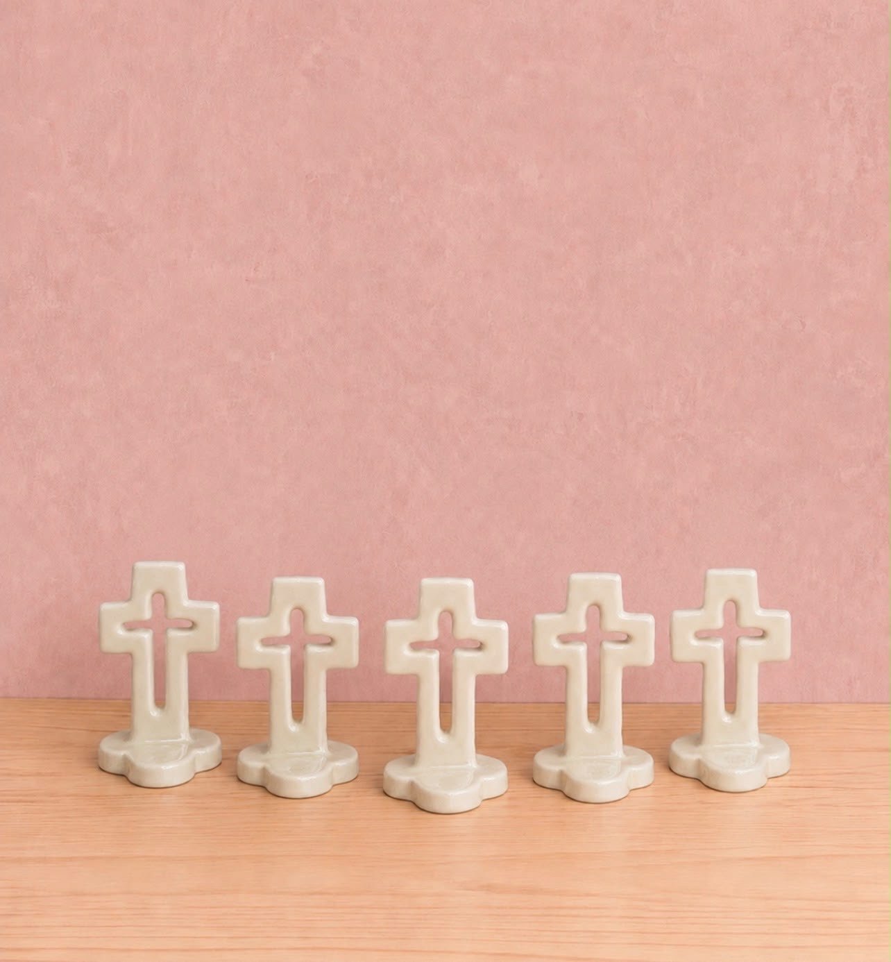 Cruces caladas para recuerdo sobre fondo rosa